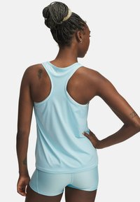 Débardeur de sport bleu clair avec un design à dos nageur, fabriqué à partir d'un tissu lisse et extensible. Présente un marquage minimal le long de l'encolure.