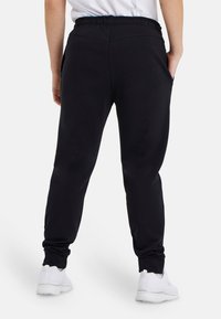 Arena UNISEX - Jogginghose - schwarz