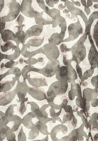 Motif damassé floral abstrait en gris et rose clair sur un fond de tissu blanc, avec une texture douce semblable à de l'aquarelle et des plis.