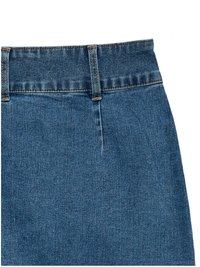 Gros plan de la partie supérieure d'un jean en denim bleu montrant les passants de ceinture, la ceinture et les coutures détaillées sur le tissu.