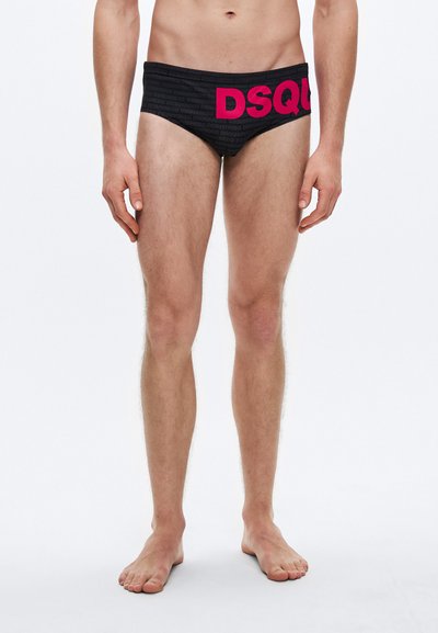 Black swim briefs with a textured pattern and a vibrant pink "DSQUARED" logo across the waistband, made from stretchy fabric.