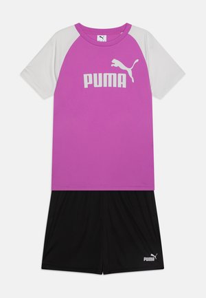 Lila és fehér rövid ujjú póló "PUMA" logóval, fekete rövidnadrággal, amelynek szárában kis "PUMA" logó található.