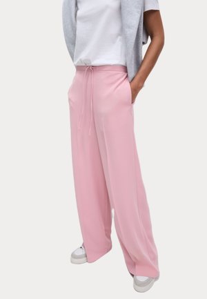 Pink wide-leg pants made of smooth material, featuring an elastic waistband with drawstring and side pockets. Worn with a gray sweater and white shirt.