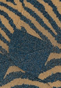Tessuto lavorato a maglia di colore beige con accenti blu e metallici. Presenta un motivo a strisce da tigre, evidenziando la texture e il contrasto di colori.