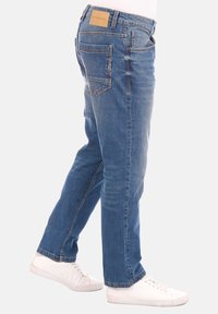 Jeans de mezclilla azul con un diseño de pierna recta, cinco bolsillos, costuras en contraste y un parche de cuero con la marca en la cinturilla.