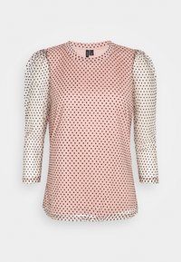 Top rosa con pois neri, dotato di maniche bianche semitrasparenti con pois neri, scollatura tonda e maniche di tre quarti.
