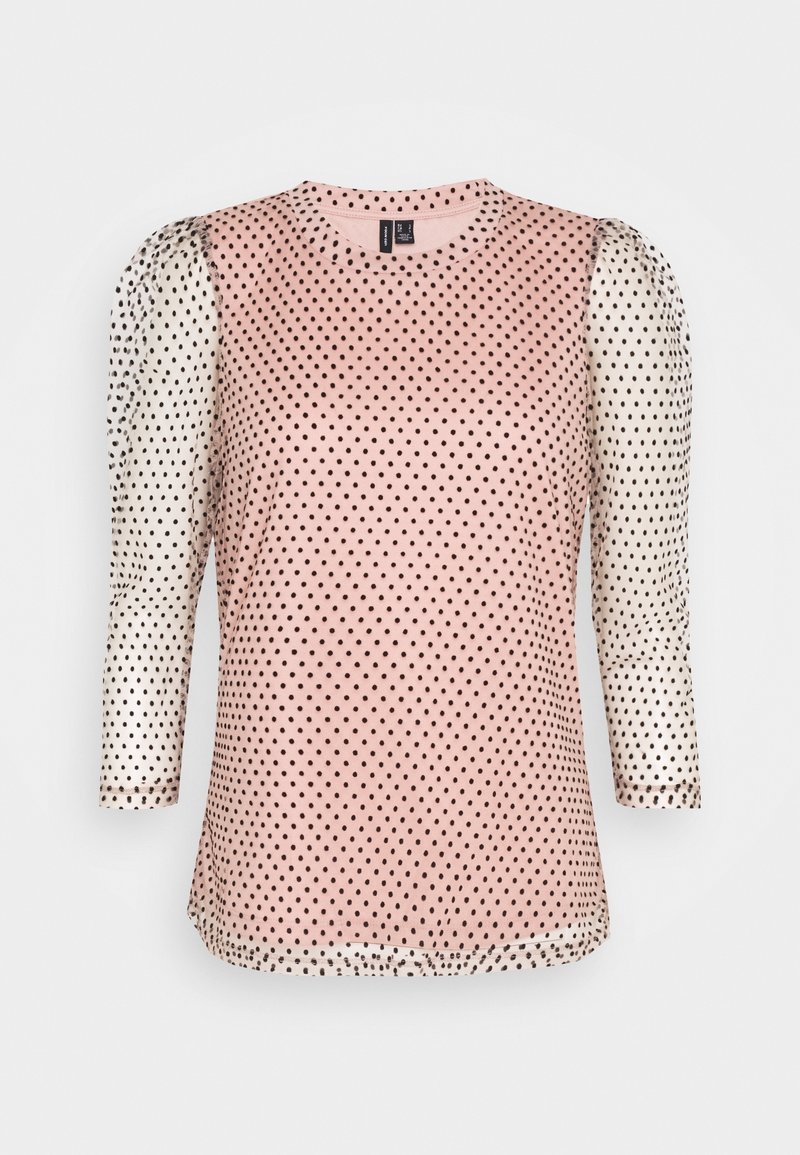 Top rosa con pois neri, dotato di maniche bianche semitrasparenti con pois neri, scollatura tonda e maniche di tre quarti.