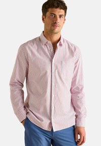 Pruhovaná košeľa na gombíky v bielej, červenej a modrej farbe. Má dlhé rukávy, golier a vrecko na ľavej hrudi. Zmes bavlny.