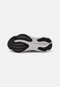 Black rubber outsole with textured grip patterns, curved shape, and a slight white midsole. Features a smooth, clean design.