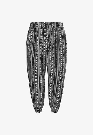 Mustat ja valkoiset kuvioidut housut, joissa on joustava vyötärö. Niissä on pystysuorat raidat ja geometrisia kuvioita. Housut on käärityt nilkoista.