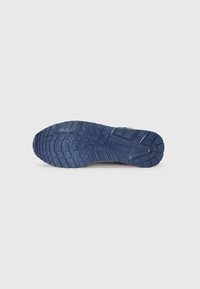 Shoe sole features a textured, blue rubber base with a patterned tread for grip and support. Designed for durability and outdoor use.