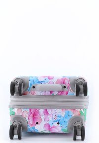 Wheeled suitcase with floral print in pink, blue, and green. Hard shell, gray handle, and black wheels. Features zipper closure.