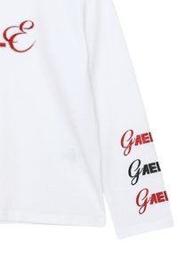 Camicetta bianca a manica lunga con testo in glitter rosso e nero "GAEL" sulle maniche e sul petto. Realizzata in morbido cotone.
