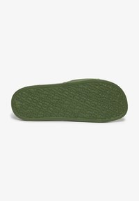 Groene rubberen schoenzool met een getextureerd patroon en gegraveerd merk. Glad afgewerkte randen en een lichte kromming voor een comfortabele pasvorm.