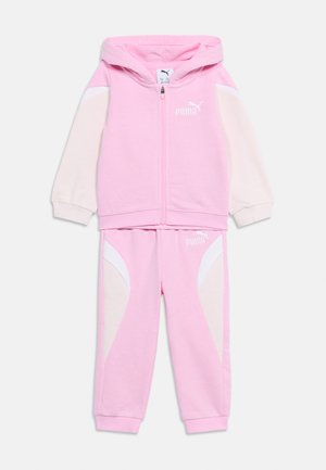 Barnas rosa og kremfargede Puma to-delte treningstøy med glidelås hettegenser og joggebukser med elastisk midje, med Puma-logo på bryst og lår.