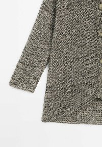 Cardigan à manches longues en maille avec fil gris et noir, motif texturé, boutons sur le devant et ourlet incliné sur fond blanc.