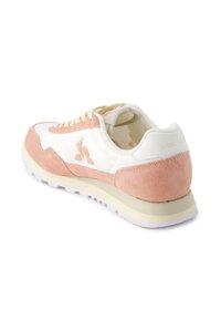 Sneaker bianca e rosa con tallone e accenti in suede, caratterizzate da un design testurizzato, lacci rotondi e un logo discreto sul retro.