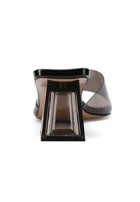 Sandal con tacco trasparente e sopra nera, con pannelli laterali trasparenti. Presenta un tacco di blocco con design geometrico e una finitura liscia e lucida.