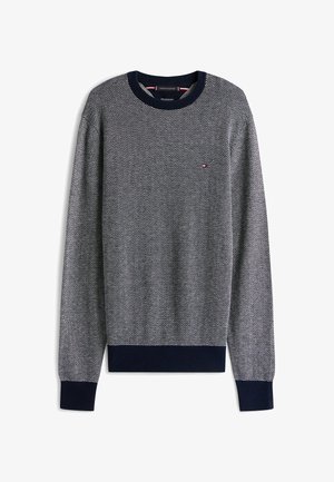 Sweater de patrón espiga en azul marino y blanco con cuello y puños acanalados. Pequeño logo en rojo, blanco y azul en el pecho.