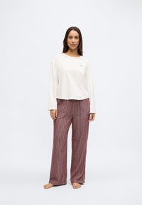 Krēmkrāsas garām piedurknēm topiņš ar pogām kakla daļā, kopā ar bordo krāsas svītrainām plaša piegriezuma biksēm. Mīksts audums ar brīvu piegriezumu.