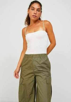 Top de tirantes finos blanco ajustado combinado con pantalones de cargo de pierna ancha en verde oliva, con bolsillos laterales y una cinturilla elástica.