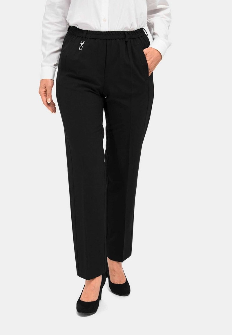 Zwarte rechte broek met een elastische tailleband, zijzakken en een zilveren hardwareaccent. De stof lijkt soepel en licht van gewicht.