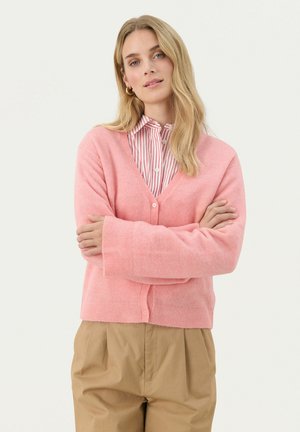 Pink cardigan made of soft material, featuring a V-neck, long sleeves, and button closure. Worn over a striped collared shirt.