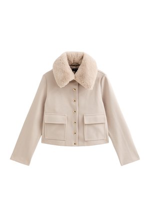 Veste courte beige avec col en fausse fourrure, fermetures à boutons dorés et deux poches avant. Texture douce et design structuré.