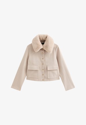 Beige cropped jack met een nepbontkraag, gouden knoopsluitingen en twee voorzakken. Zachte textuur en gestructureerd ontwerp.