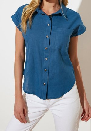 Blauw overhemd met korte mouwen en knopen, met een borstzak, gemaakt van een gestructureerde stof, voorzien van zilverkleurige knopen en een afgeronde zoom.