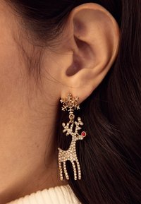 Gold-tone earrings featuring a snowflake stud and a dangling reindeer adorned with clear crystals and a red nose.