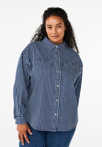 Camicia a righe blu e bianche con colletto, due tasche frontali e maniche lunghe, realizzata in tessuto di cotone texturizzato.