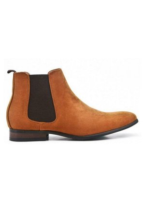 Bottines en daim tan avec un panneau latéral élastique noir. Bout rond, petit talon empilé et tirette à l'arrière. Texture lisse.