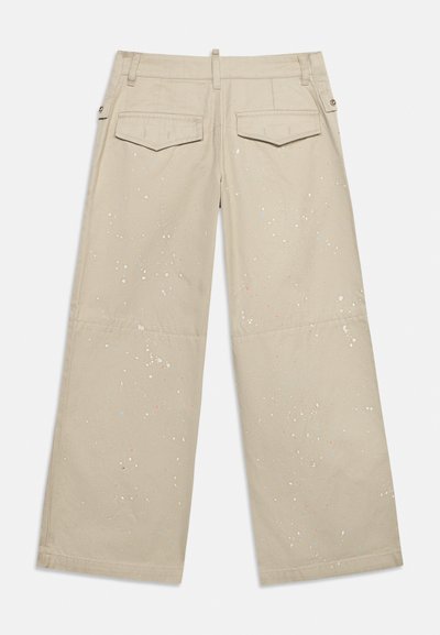 Pantalon beige à jambes larges avec poches à rabat à l'arrière, passants pour ceinture, et un léger motif de taches de peinture multicolores.