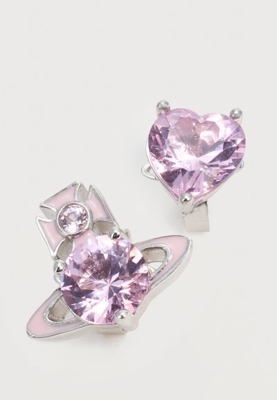 Două inele în ton argintiu cu pietre prețioase mari roz, unul în formă de inimă și unul rotund, cu modele de inel planetar și coroană.
