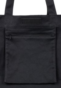 Černá plátěná taška na rameno s přední kapsou na zip, zesílenými rukojeťmi a uzávěrem na suchý zip. Kvalitní a texturovaná tkanina.