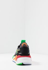 Black mesh sneaker with multicolor accents, including green, orange, and red. Features a padded collar and textured rubber sole.
