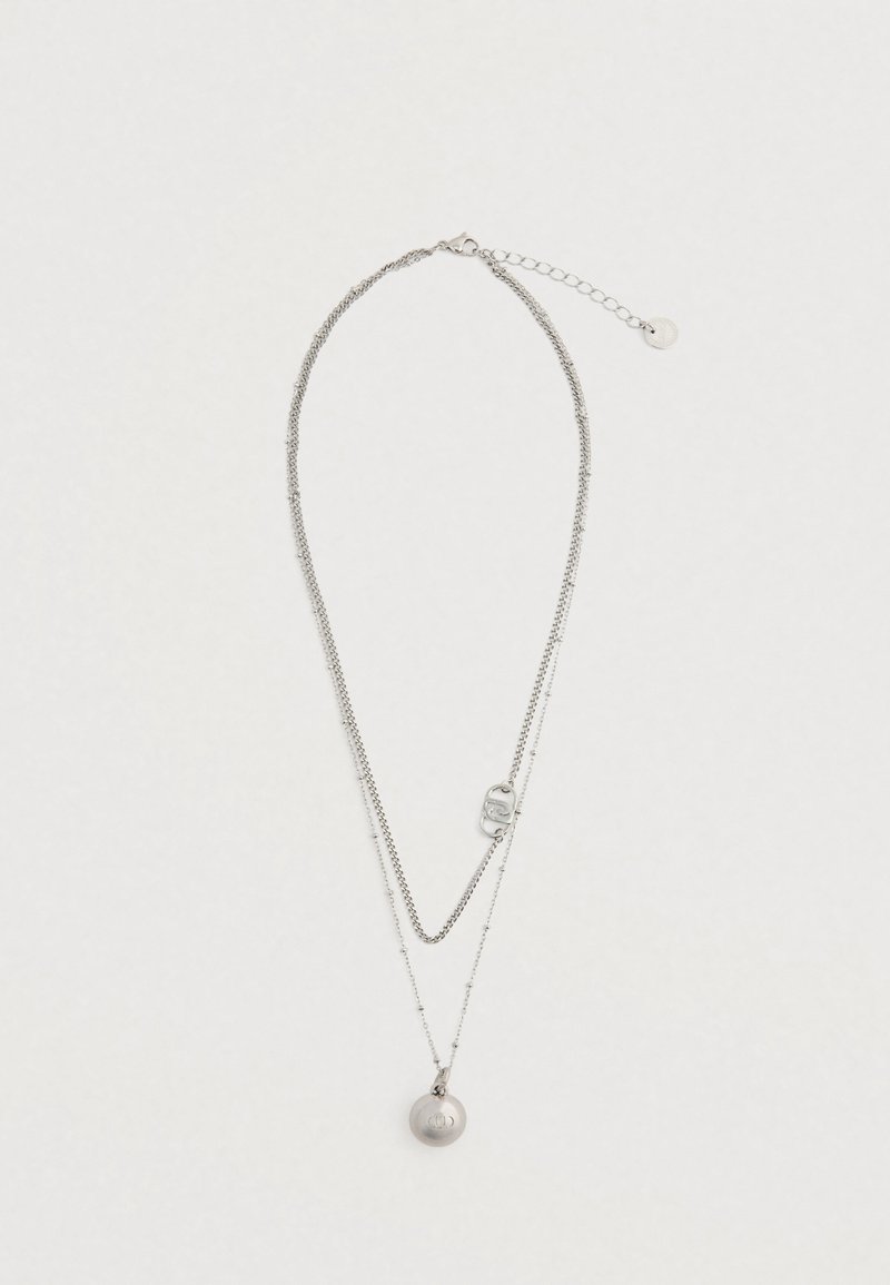 Srebrny naszyjnik warstwowy z dwiema łańcuszkami; jeden gładki, a drugi koralikowy, z okrągłym zawieszką i zapięciem z przedłużanym łańcuszkiem.