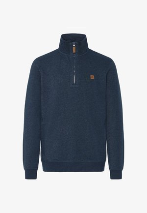 Navy kék pulóver magas gallérral, félig zippel és barna bőr folttal. Texturált anyagból készült, bordázott mandzsettákkal és aljjal.