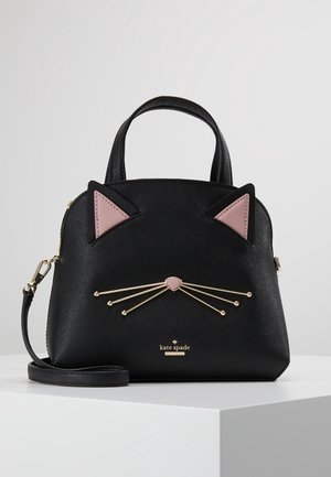Black handbag with cat features, textured synthetic material, pink ear accents, gold whiskers, and a detachable strap. Brand name displayed.