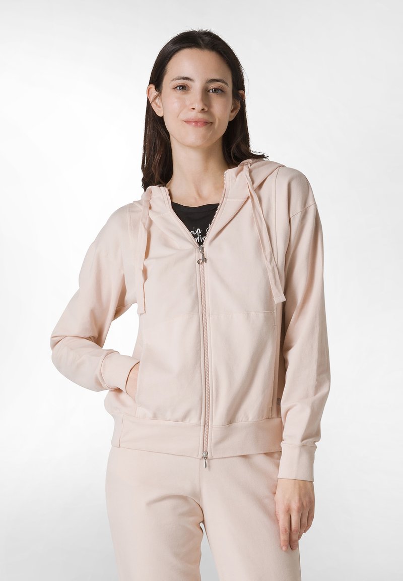 Sudadera ligera de color rosa claro con cremallera, hecha de una tela suave, con un bolsillo tipo canguro y capucha con cordón. Incluye puños y dobladillo acanalados.