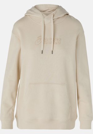 Beige mikina s kapucí, přední kapsou, šňůrkami a vyšitým logem. Vyrobena z měkké látky, má volný střih a žebrované manžety.