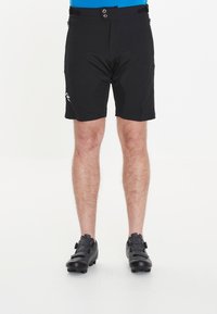 Svarta cykelshorts med texturerad tyg, med två framknappar, dragkedjefickor och en broderad logotyp på vänster ben.