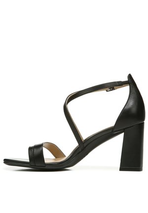 Schwarze Leder-High-Heelsandalen mit offener Spitze, ausgestattet mit überkreuzten Riemen und einem Blockabsatz für Stabilität. Glatte Textur mit minimaler Ausstattung.