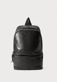 Zwarte leren rugzak met een gladde afwerking, een handvat aan de bovenkant en een ritscompartiment aan de voorkant voor extra opbergruimte.