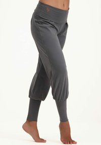 Graue, cropped Leggings mit einem breiten Bund, die am Knöchel mit einem gerafften Detail versehen sind und ein kleines Logo in der Nähe des Bundes haben. Weiche Stofftextur.