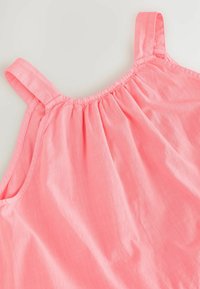 Top sin mangas de color rosa con escote fruncido y tirantes delgados. Suave textura y tejido ligero que transmiten un diseño casual.
