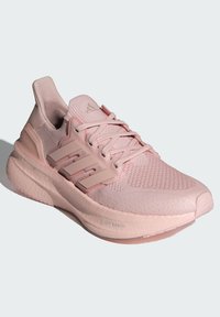 Lys rosa treningssko med et teksturert mesh-overdel, forsterkede detaljer og en tykk, polstret såle merket "LIGHTBOOST."