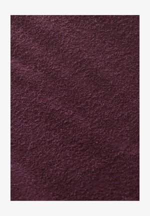 Bordeauxkleurige textiel met een zachte, licht pluizige oppervlakte, met een egale, rijke kleur en subtiele variaties in textuur.