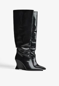 Čierne, lesklé čižmy po kolená s voľným strihom, klinovým podpätkom, špicatou špičkou a hladkým syntetickým materiálom. Žiadne viditeľné prvky alebo vzory.